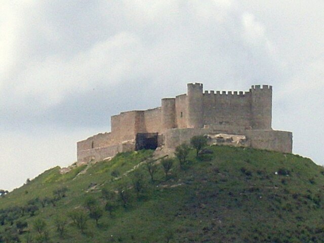 El castillo de Jadraque en el monte con una pradera verde